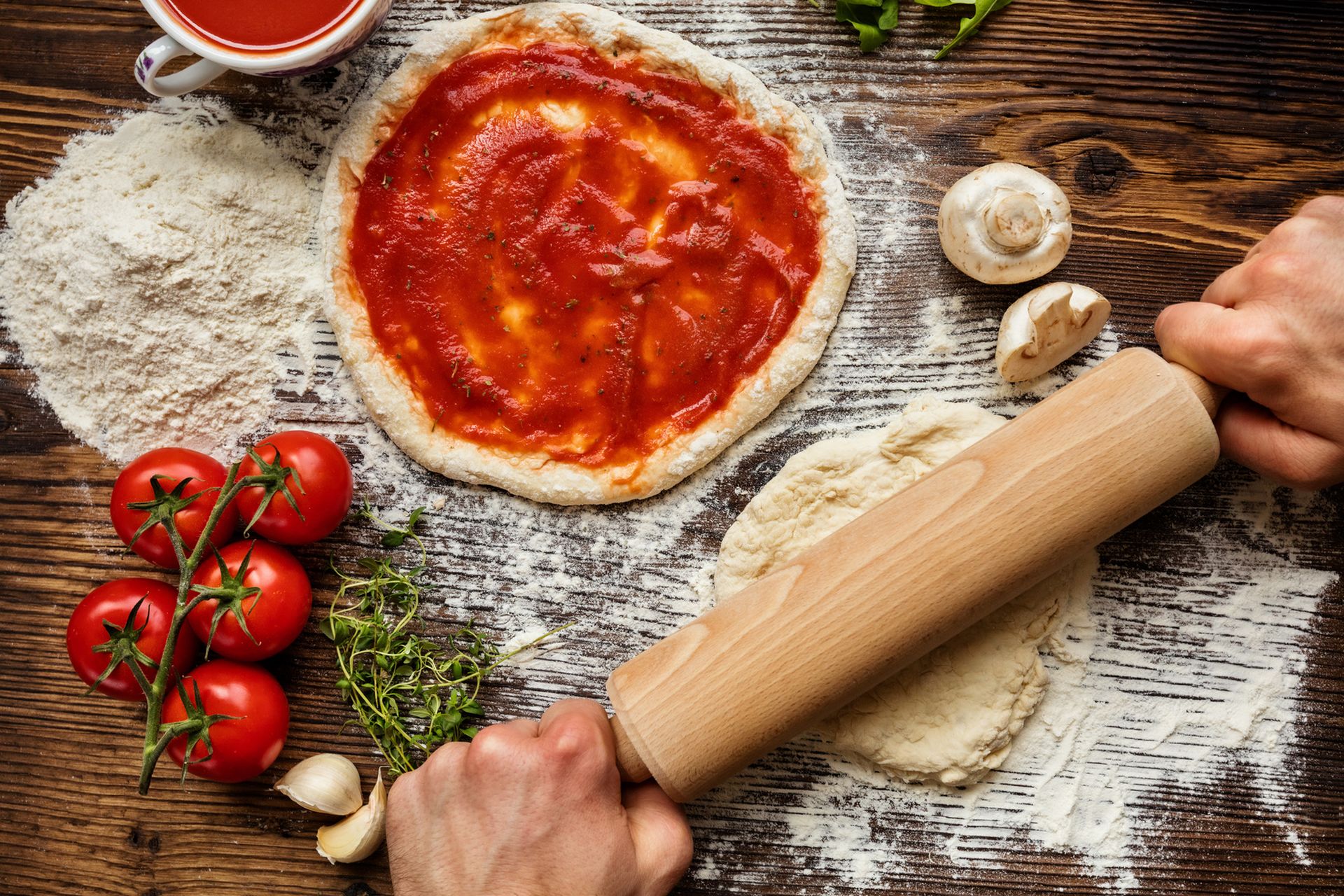 Fresh original Italian raw pizza preparation, close-up of man hands in action